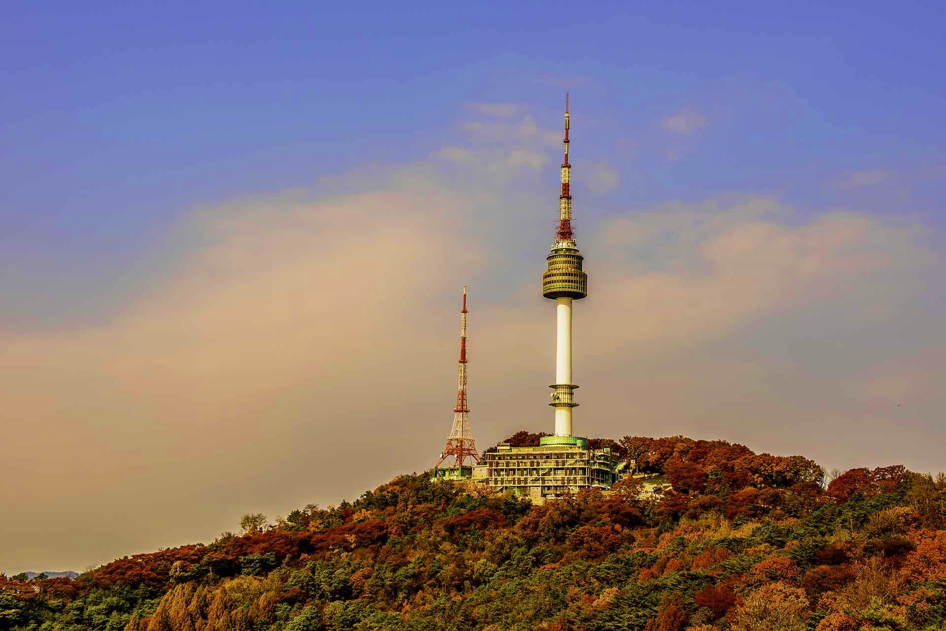South Korea Visa Namsan Tower and broadcasting antenna on a forested hillside in Seoul, South Korea during autumn with changing foliage